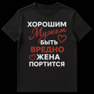 Close-up of a black t-shirt featuring a humorous Russian phrase 'Being a good husband is harmful, the wife gets spoiled' in white and red fonts with two red hearts. on Black t-shirt