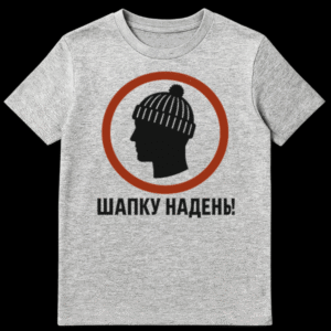 Mockup of a t-shirt featuring a black silhouette of a head wearing a beanie with a pom-pom, enclosed within a reddish-brown circle. Below the graphic, the Russian text "ШАПКУ НАДЕНЬ!" (Put on your hat!) is printed in light gray. on Sports Grey t-shirt